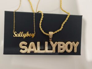 Two gold nameplate necklaces on a flat surface at jewelry dealer in Burbank