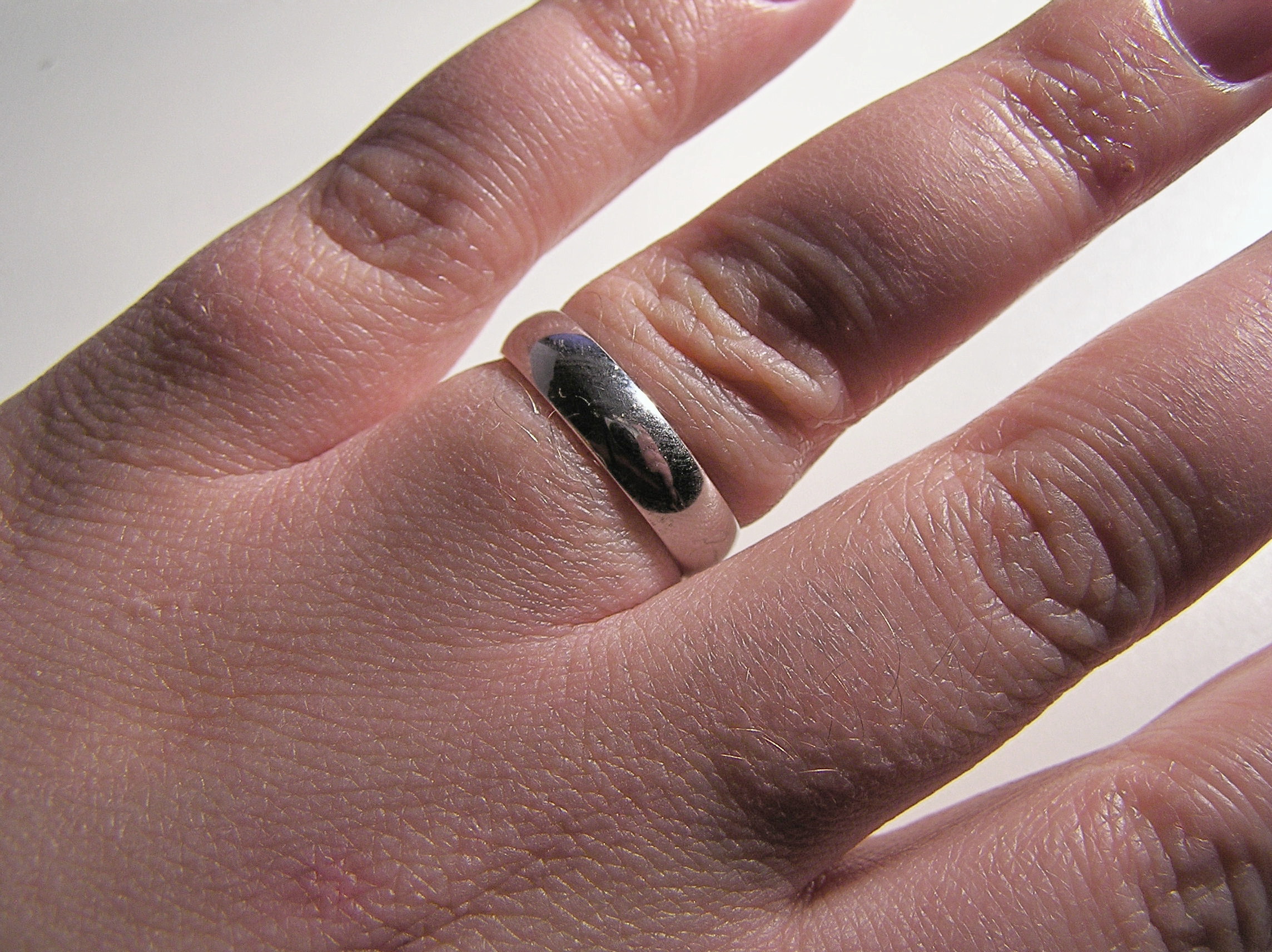 A white gold wedding ring photographed against a plain background